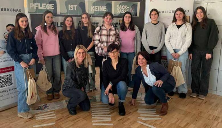Eine Gruppe von jungen Schülerinnen steht lächelnd in einem Raum, während drei Frauen im Vordergrund knien, vor einem Hintergrund-Plakat mit der Aufschrift „Pflege ist keine Sackgasse“ und Logos des Ordensklinikums Innviertel und TAU Kolleg (FraCampus) Braunau.