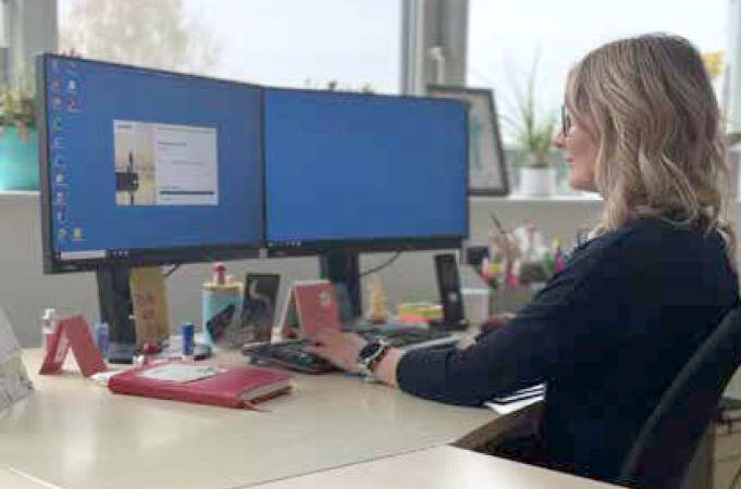 Michaela Ober, Direktorin des FraCampus, arbeitet konzentriert an einem Schreibtisch mit zwei großen PC-Bildschirmen in einem hellen Büro.